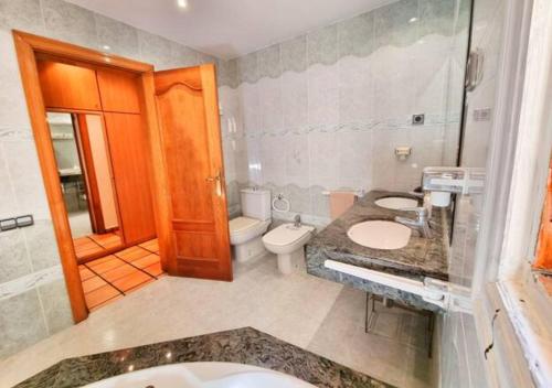a bathroom with two sinks and a toilet and a shower at Casa Donaire, alojamiento turístico in Marganell