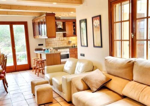 a living room with a couch and a kitchen at Casa Donaire in Marganell