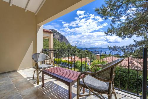 balcón con mesa, sillas y vistas al océano en Alya Villa Butik Hotel, en Turunç