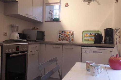 a kitchen with a table and a chair in it at Gîte La Grange d'Herbuchenne in Dinant