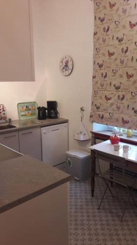a kitchen with a counter and a table in it at Gîte La Grange d'Herbuchenne in Dinant