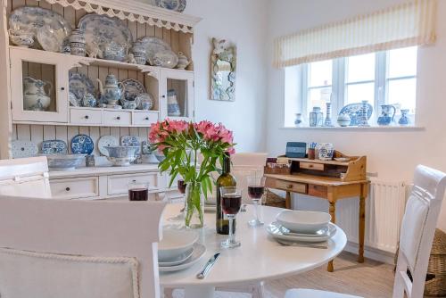 a dining room with a table with a vase of flowers at 4 Ropers Court, Lavenham in Lavenham