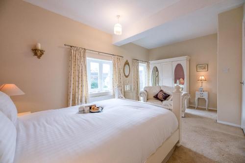 een slaapkamer met een groot wit bed en een raam bij 4 Ropers Court Lavenham in Sudbury