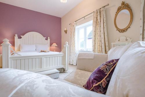 a bedroom with a bed and a chair and a mirror at 4 Ropers Court, Lavenham in Lavenham