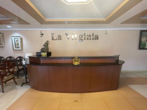a reception desk in a hotel lobby with a sign on the wall at La Virginia Leisure Park and Amusement in Mataasnakahoy