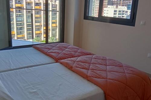 Ce lit se trouve dans un dortoir doté de 2 grandes fenêtres. dans l'établissement Loyito's seaviews apartment La Cala, à Benidorm