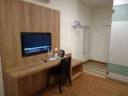 a room with a desk with a television on a wall at Greencity Hotel in Sungai Petani