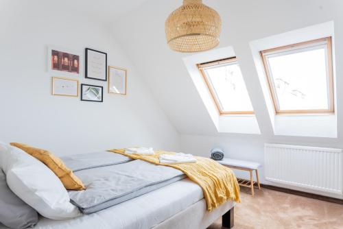 a white bedroom with a bed and two windows at Floral Apartment - NEW in town in Budapest