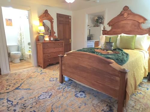 a bedroom with a large wooden bed and a mirror at Victorian Apt at SanctuaryoftheSwan dog friendlyhotel alternative farm stay in Birdsboro