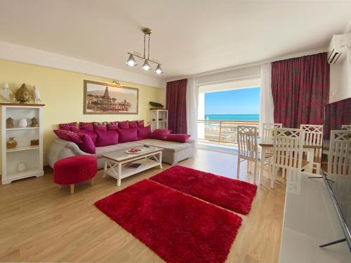 a living room with a red couch and a red rug at Boutique Citadel in Eforie Nord