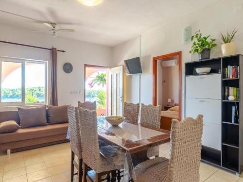- une salle à manger avec une table, des chaises et un canapé dans l'établissement Apartments Žaknić, à Prižba