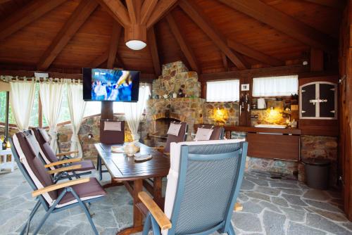 - une salle à manger avec une table, des chaises et une télévision dans l'établissement Holiday, party and relax vila, 