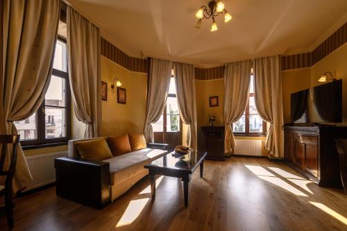 a living room with a couch and some windows at Hotel Iosefin Residence in Timişoara