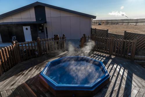 a jacuzzi tub on a deck next to a building at Hotel Kvika in Ölfus