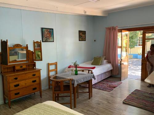 a bedroom with a bed and a table with a tableablish at ArtKaroo Stay in Oudtshoorn