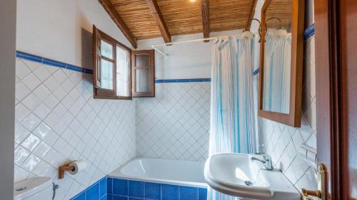 uma casa de banho com um lavatório, uma banheira e um chuveiro em Molino Maroto Alhaurín el Grande by Ruralidays em Alhaurín el Grande