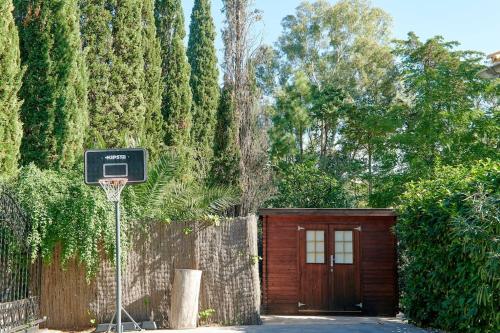 un aro de baloncesto frente a un garaje de madera en Villa Esquina Luxury 5 Bed 5 Bath Pollensa en Pollença