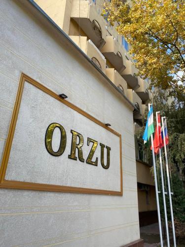a sign on the side of a building with flags at ORZU HOTEL in Namangan