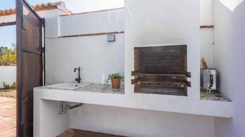 baño con lavabo y chimenea en Marrucho Alto Riogordo by Ruralidays, en Ríogordo