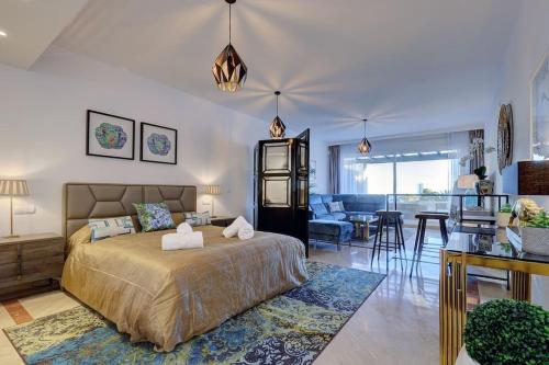 a bedroom with a bed and a living room at Luxurious 80m² studio apartment, stunning sea views - Rio Real Golf, Marbella in Marbella