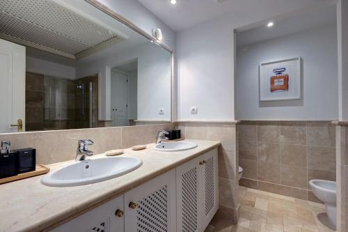 a bathroom with two sinks and a mirror at Luxurious 80m² studio apartment, stunning sea views - Rio Real Golf, Marbella in Marbella