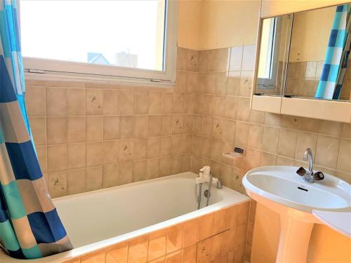 une salle de bain avec une baignoire et un lavabo dans l'établissement Quiberon - Appartement 2 pièces avec balcon, parking et animaux acceptés - FR-1-478-74, à Quiberon