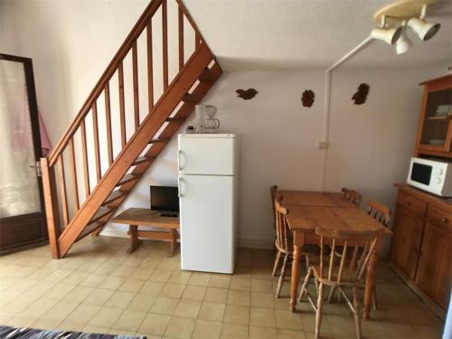 Il dispose d'une cuisine avec une table et un réfrigérateur. dans l'établissement Villa T2+Mezzanine 6 Pers, Terrasse, Parking, Face Mer - FR-1-81-350, à Port-Leucate