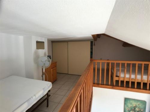Cette chambre comprend un lit et un escalier en bois. dans l'établissement Villa T2+Mezzanine 6 Pers, Terrasse, Parking, Face Mer - FR-1-81-350, à Port-Leucate
