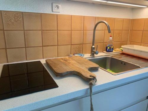 une cuisine avec une planche de coupe en bois sur un évier dans l'établissement Villa mitoyenne avec piscine, parking, climatisation et proche mer, idéale pour 4 personnes - FR-1-607-89, au Cap d'Agde