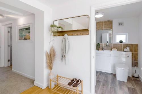 a white kitchen with a sink and a mirror at Fen Lane Retreat in Norwich