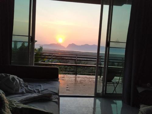 a room with a view of the sunset from a balcony at Ao Luek Panoramic Pool-SHA Plus in Ao Luk