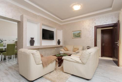 a living room with two white chairs and a table at Summer retreat in Kotor