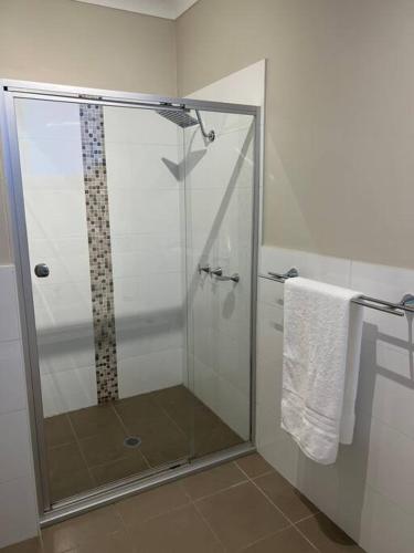 a shower with a glass door in a bathroom at Surfmist Barrack Point in Barrack Point