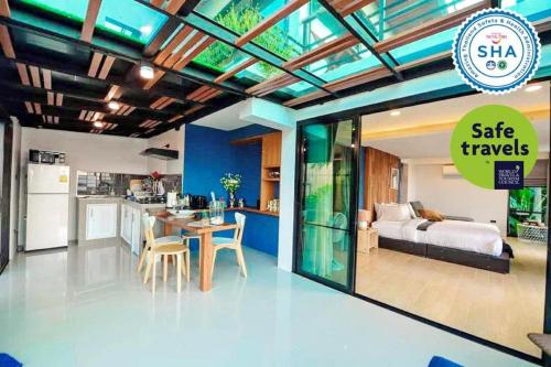 a room with a bed and a kitchen with a table at Ao Luek Panoramic Pool-SHA Plus in Ao Luk