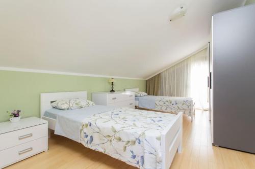 a white bedroom with a bed and a dresser at Summer retreat in Kotor