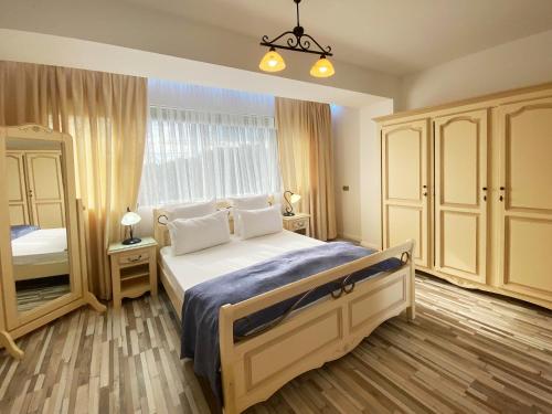 a bedroom with a bed and a large window at Boutique Citadel in Eforie Nord