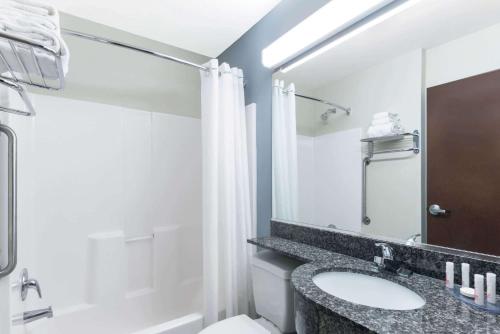 uma casa de banho com um lavatório, um WC e um chuveiro em Microtel Inn and Suites Baton Rouge Airport em Baton Rouge