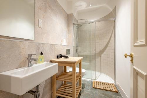 a bathroom with a sink and a shower at Queen's Gardens Apartment - 2 Bed - Central in St. Andrews