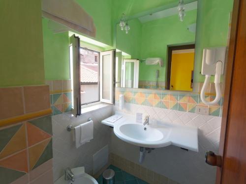 La salle de bains est pourvue d'un lavabo et d'un miroir. dans l'établissement Hotel Clelia, à Ustica