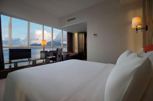 a bedroom with a white bed and a view of the ocean at Best Western The Lagoon Hotel in Manado