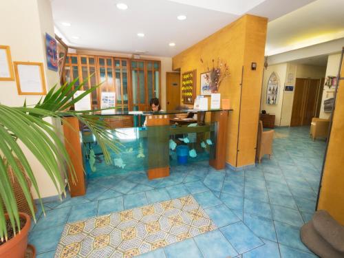 a woman sitting at a counter in a lobby at Hotel Clelia in Ustica
