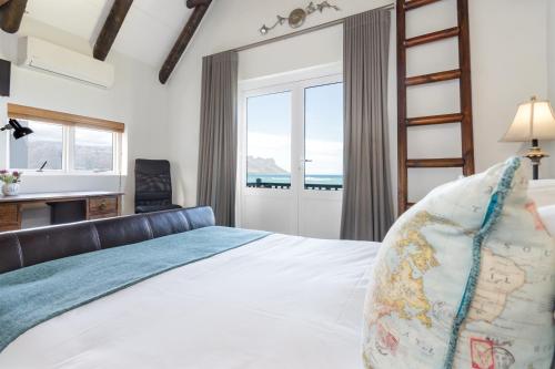 a bedroom with a bed with a view of the ocean at Strand Beach Lodge in Strand