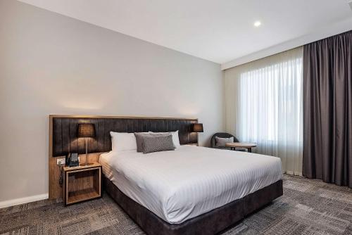 a hotel room with a bed and a window at Ingot Hotel Perth, Ascend Hotel Collection in Perth