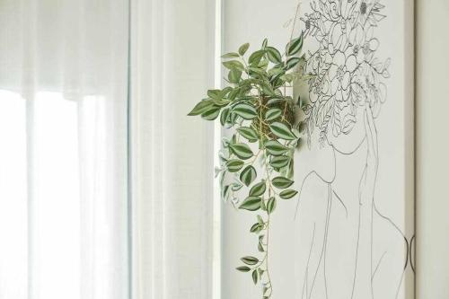 a plant in a vase next to a window at CASA ROLAO Elegante Casa Familiar 10 personas in Sierra de Outes