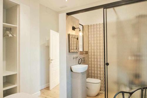 a bathroom with a toilet and a glass shower at CASA ROLAO Elegante Casa Familiar 10 personas in Sierra de Outes