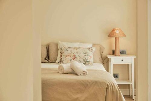 a bedroom with a bed with a lamp on it at CASA ROLAO Elegante Casa Familiar 10 personas in Sierra de Outes
