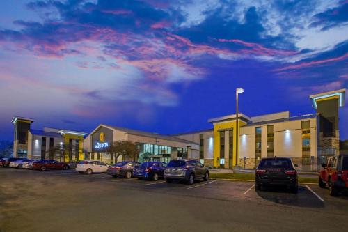 a parking lot with cars parked in front of a building at La Quinta Inn & Suites by Wyndham Detroit Metro Airport in Romulus