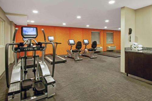 a fitness room with a row of exercise machines at La Quinta Inn & Suites by Wyndham Detroit Metro Airport in Romulus