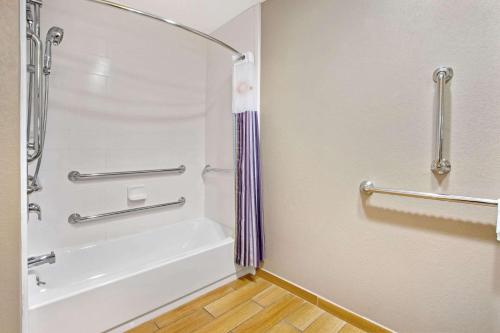 a bathroom with a shower and a tub at La Quinta Inn & Suites by Wyndham Detroit Metro Airport in Romulus