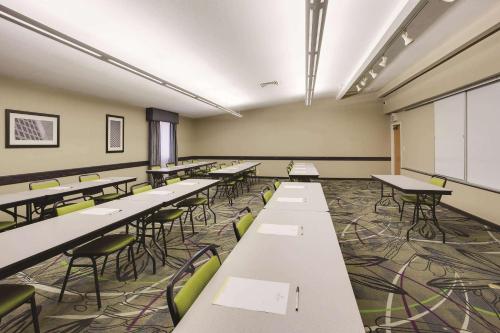 an empty classroom with rows of tables and chairs at La Quinta Inn & Suites by Wyndham Detroit Metro Airport in Romulus